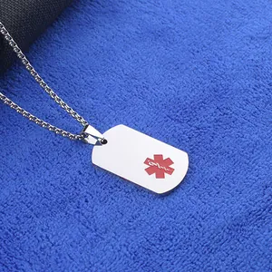 Primer plano del colgante médico de acero inoxidable con símbolo rojo sobre fondo azul