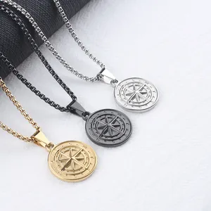 Detailed view of stainless steel compass coin pendants in gold, silver, and black finishes