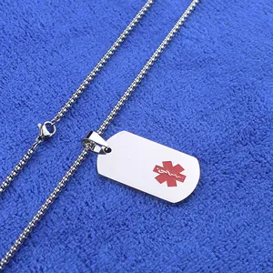 Primer plano de placa médica de acero inoxidable con estrella de vida roja sobre tela azul