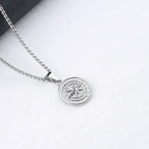 Detailed close-up of a silver compass coin pendant with N E S W engraving on a box chain