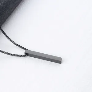Close-up of minimalist black rectangle pendant with matte finish on a box chain