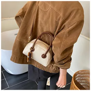 Vue détaillée du sac Boston vintage crème avec poignées brunes et breloque en perles