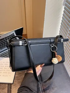 Sac Baguette Minimaliste en Cuir PU pour Femmes Sac à Bandoulière Simple Avec Pendentif Boule en Peluche Couleur Unie