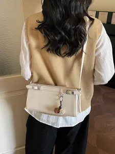 Sac baguette minimaliste beige crème à double boucle avec pendentif floral et bandoulière