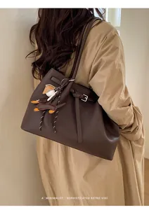 Detail der dunkelbraunen Leder-Tote mit silberner Schnalle und Dackel-Anhänger-Dekor