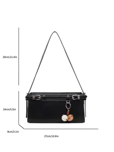 Sac baguette noir minimaliste avec détails argentés et pendentif décoratif en peluche