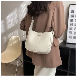 Gros plan sur le sac seau blanc crème avec cuir grainé litchi et bandoulière réglable