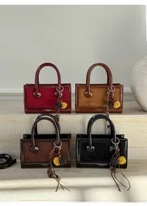 Vue détaillée de quatre sacs à main bicolores avec des pompons décoratifs élégants