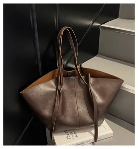 Vue détaillée du grand sac cabas marron foncé avec cordons décoratifs et texture grainée