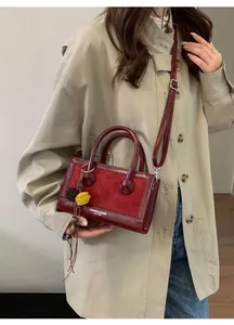 Détails du sac baguette rouge rétro en similicuir verni et daim avec patchwork chic