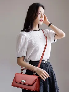 Elegant reddish-brown leather baguette handbag with silver metal buckle on white shirt model