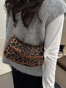 Elegante borsa baguette leopardata con catena dorata indossata per un look moderno