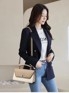 Chic two-tone baguette bag styled with a navy blazer and white graphic t-shirt