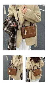 Brown checkered handbag with bead charm detail styled with an oatmeal winter coat