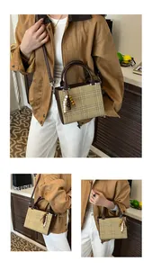 Detail of vintage beige and brown plaid square handbag with dual handles and beaded tassel