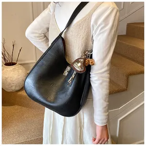Détail du sac hobo noir avec fermoir rotatif argenté et pendentif miroir en cœur