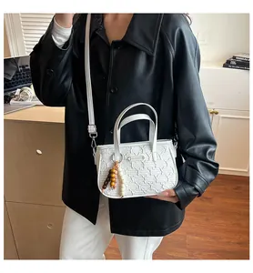 Détail du mini sac blanc avec motif Y gaufré, bandoulière amovible et breloque en perles