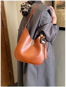 Détail du sac seau marron caramel avec fermoir rotatif argenté et bijou de sac léopard