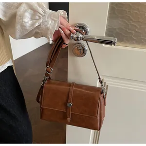 Détail du sac à main en cuir marron caramel avec finitions argentées et rabat élégant