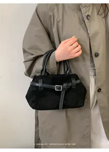 Détail du sac à main noir mat avec sangles en cuir et boucles métalliques de qualité