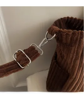 Detail of durable silver metal swivel hook and adjustable buckle on brown corduroy tote bag