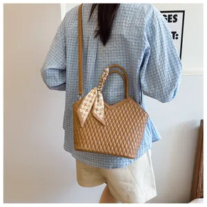 Vue détaillée du sac seau marron matelassé avec foulard en soie et bandoulière