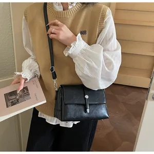 Détail du sac à main noir rétro avec boucle en métal argenté et bandoulière réglable