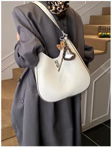 Détail du sac seau en cuir plissé blanc avec ruban léopard et pendentif en forme de cœur