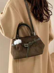 Sac bandoulière en daim vert olive avec breloque peluche sur manteau en laine beige