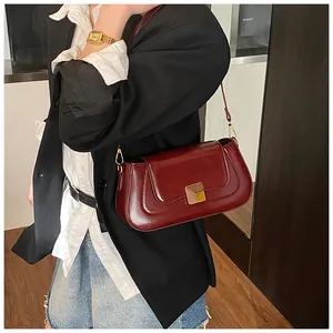 Seitenansicht der luxuriösen dunkelroten Baguette-Tasche aus Lackleder mit Goldverschluss