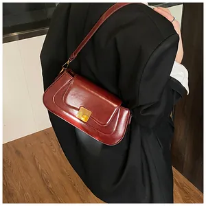 Detailansicht der weinroten Leder-Baguette-Tasche mit elegantem goldenem Metallschnitt