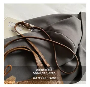Detail of brown lychee grain leather bucket bag with adjustable shoulder strap