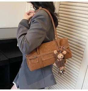 Detail of vintage brown tote bag with bear charm worn with a grey blazer outfit
