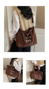 Detail of dark brown corduroy tote bag showing vertical texture and white embroidery