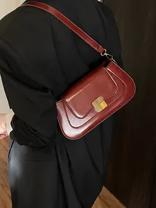 Dunkelrote Baguette-Tasche mit goldener quadratischer Schnalle, getragen von Model