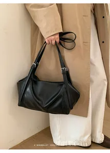 Détail du sac cabas minimaliste en cuir noir avec boucles argentées et plis rétro