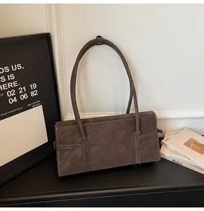 Detail view of vintage dark brown suede shoulder bag with visible stitching and long straps