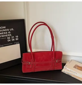 Detailed view of a vintage red suede shoulder bag featuring contrast stitching and silver buckle