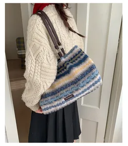 Model view of striped plush tote bag with brown leather shoulder straps and soft texture
