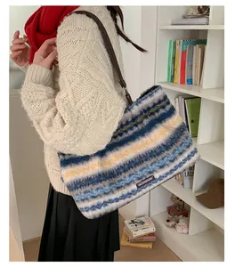 Close-up of plush striped tote bag with leather strap worn over shoulder