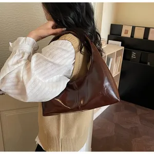 Detail of dark brown glossy hobo bag paired with vintage style chic business casual outfit