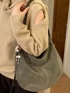 Sac hobo vert olive avec surpiq coutures contrastées blanches et pendentif bohème