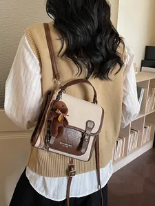 Bolso tote vintage bicolor con colgante de oso mostrado en una escena interior acogedora