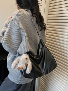 Minimalist black leather baguette bag with chain strap and cute plush bunny charm