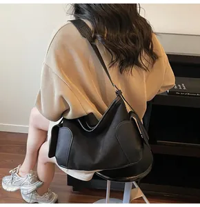 Vue détaillée du sac cabas noir montrant la texture du matériau et le design de la bandoulière