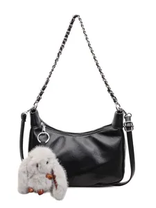 Black crescent baguette bag with silver chain and plush bunny pendant on white background