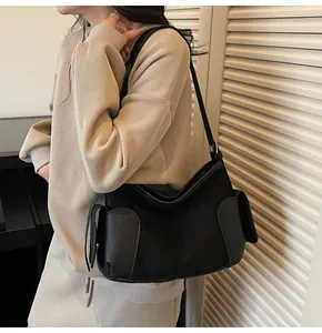 Détail du sac cabas noir minimaliste avec poches latérales et finitions en cuir