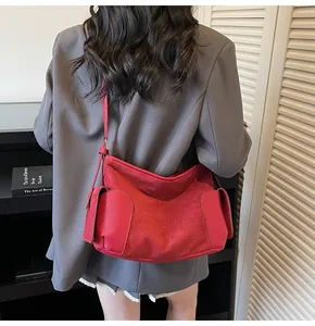 Détail du sac cabas en daim rouge avec fermeture zippée et poches latérales