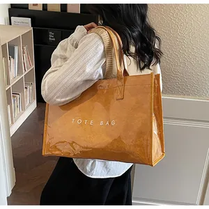 Modèle portant un sac cabas vintage orange avec revêtement PVC et lettrage blanc chic