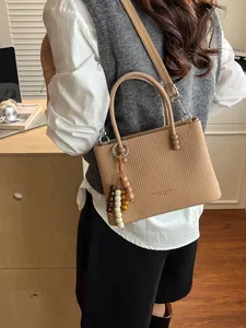 Elegant camel pleated leather crossbody bag with beaded tassel charm and top handles